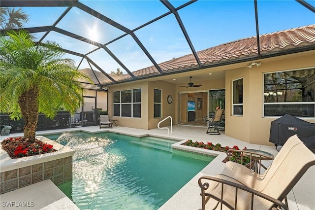 view of swimming pool with a lanai, ceiling fan, and a patio area