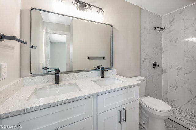 bathroom featuring vanity, tiled shower, and toilet