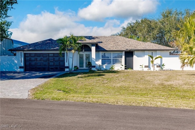 ranch-style home featuring french doors, a front lawn, and a garage