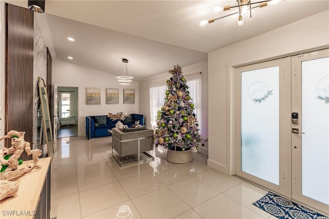 tiled entrance foyer featuring french doors, lofted ceiling, and plenty of natural light