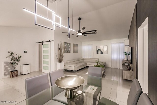 tiled living room featuring lofted ceiling, ceiling fan, and a barn door