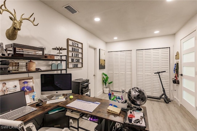 home office with light hardwood / wood-style flooring