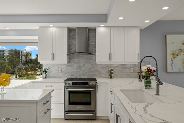 kitchen featuring sink, decorative backsplash, electric range, light stone countertops, and wall chimney exhaust hood