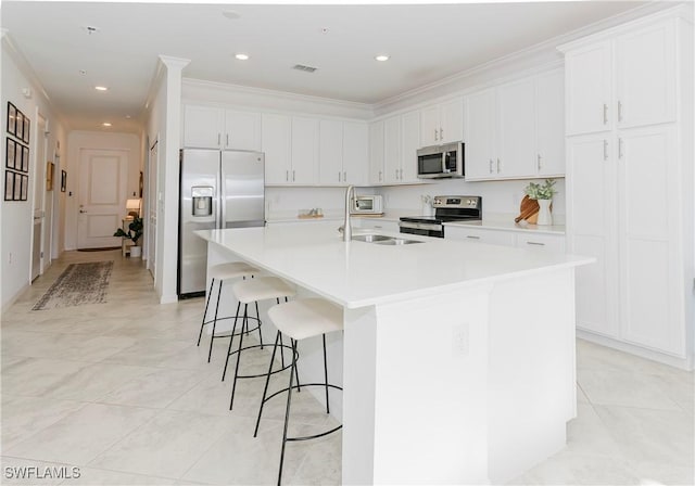 kitchen featuring white cabinetry, a kitchen island with sink, sink, and stainless steel appliances