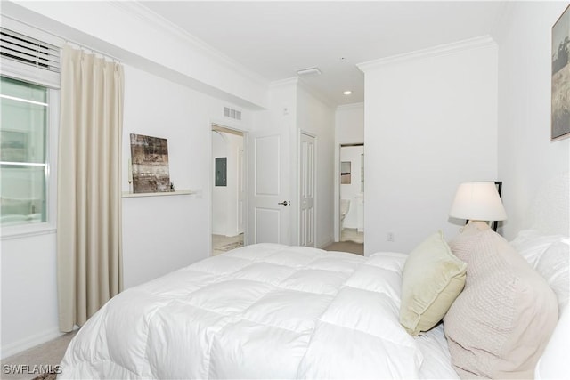 carpeted bedroom featuring a closet, ensuite bathroom, and crown molding