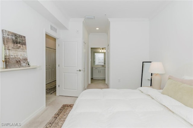 bedroom with ensuite bathroom, a closet, light colored carpet, and ornamental molding