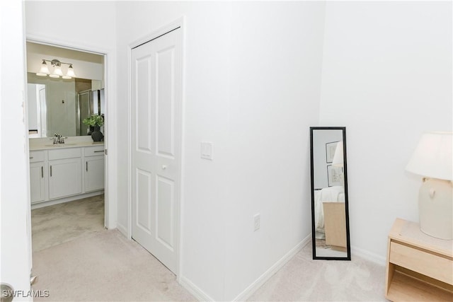 hall featuring light carpet and sink