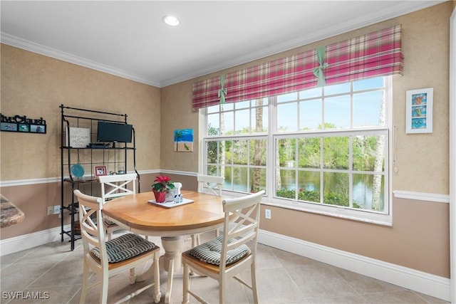 dining space featuring crown molding, a healthy amount of sunlight, and light tile patterned floors