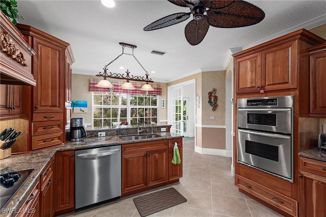 kitchen featuring pendant lighting, sink, crown molding, and stainless steel appliances