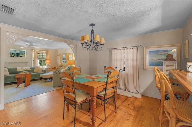 6253 Valeria Rd, Bokeelia, FL 33922 - dining space with a textured ceiling, light hardwood / wood-style flooring, and ceiling fan with notable chandelier