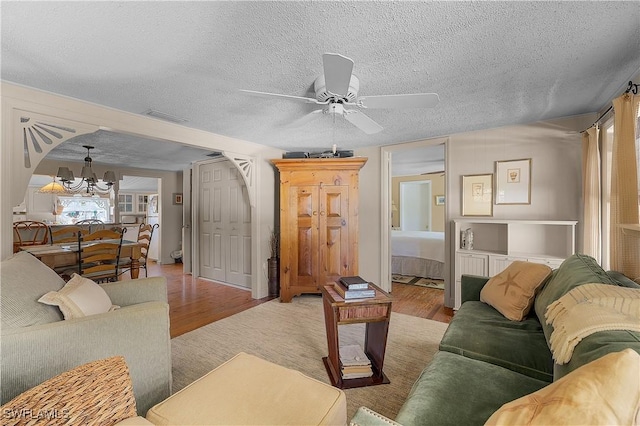 6253 Valeria Rd, Bokeelia, FL 33922 - living room with a textured ceiling, light hardwood / wood-style flooring, and ceiling fan with notable chandelier
