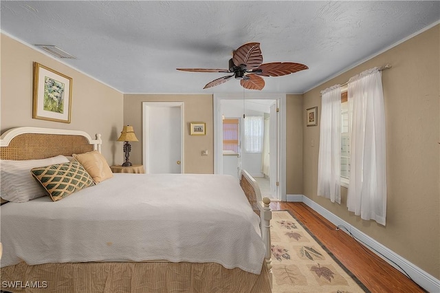 6253 Valeria Rd, Bokeelia, FL 33922 - bedroom with ensuite bath, ceiling fan, a textured ceiling, and light wood-type flooring