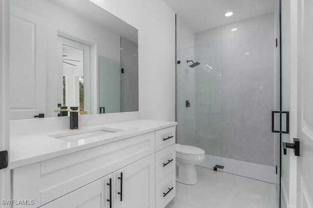 bathroom with a shower with door, vanity, and toilet