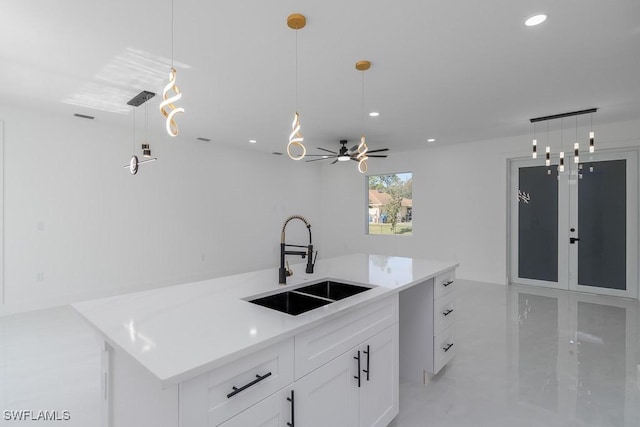 kitchen featuring white cabinets, a kitchen island, hanging light fixtures, and sink