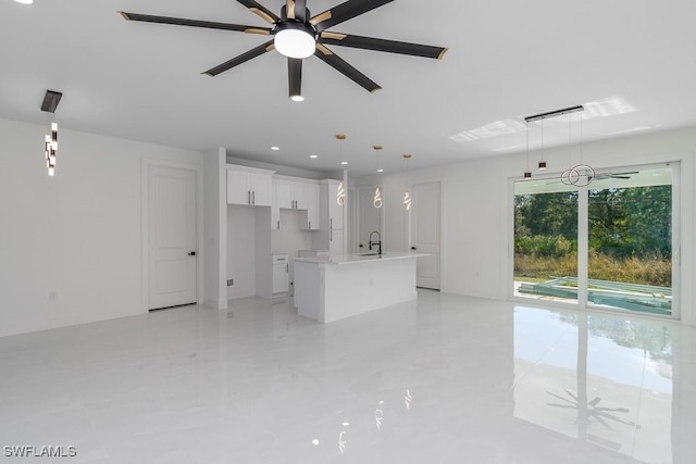 unfurnished living room featuring ceiling fan and sink