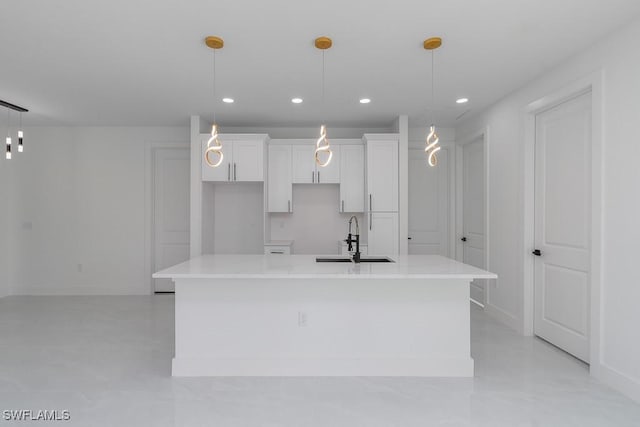 kitchen with pendant lighting, a center island with sink, and sink