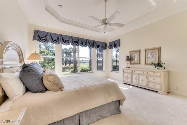 carpeted bedroom featuring a raised ceiling, ceiling fan, and crown molding