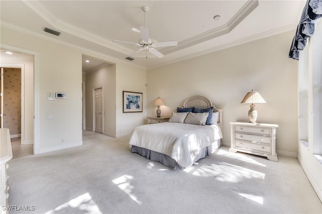 bedroom with a raised ceiling, light carpet, ceiling fan, and crown molding