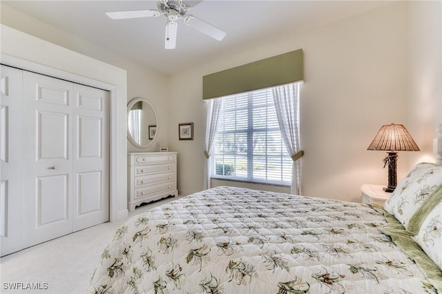 carpeted bedroom featuring ceiling fan and a closet