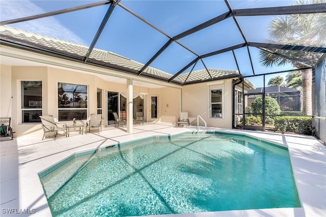 view of swimming pool with a lanai and a patio