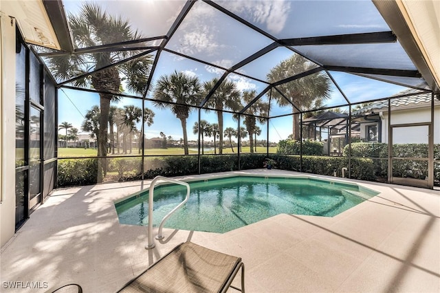 view of pool featuring glass enclosure and a patio area