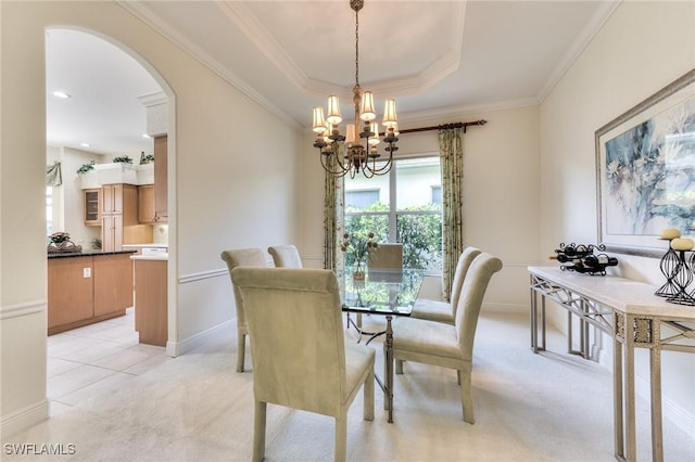 dining room featuring light colored carpet, crown molding, a chandelier, and a tray ceiling