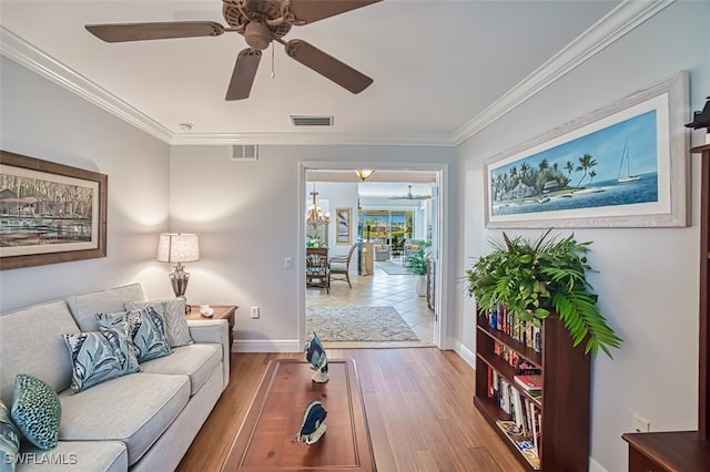 living room with ornamental molding, ceiling fan with notable chandelier, and hardwood / wood-style floors