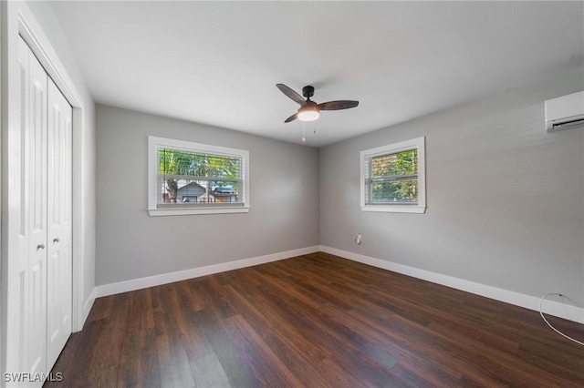 unfurnished bedroom featuring multiple windows, a wall mounted air conditioner, a closet, and ceiling fan