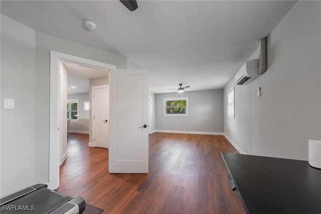 unfurnished living room with a wall mounted AC, a wealth of natural light, dark hardwood / wood-style floors, and ceiling fan