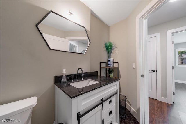 bathroom featuring vanity, wood-type flooring, and toilet