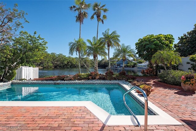 view of swimming pool with a patio and a water view