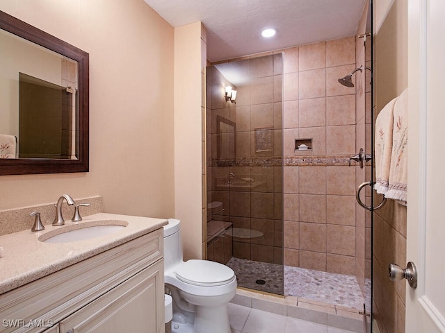 bathroom featuring tile patterned flooring, vanity, a shower with door, and toilet