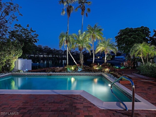 view of pool at twilight