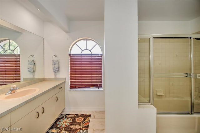 bathroom with vanity, combined bath / shower with glass door, and plenty of natural light