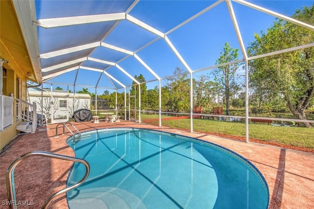 view of swimming pool with glass enclosure, a patio, and a lawn