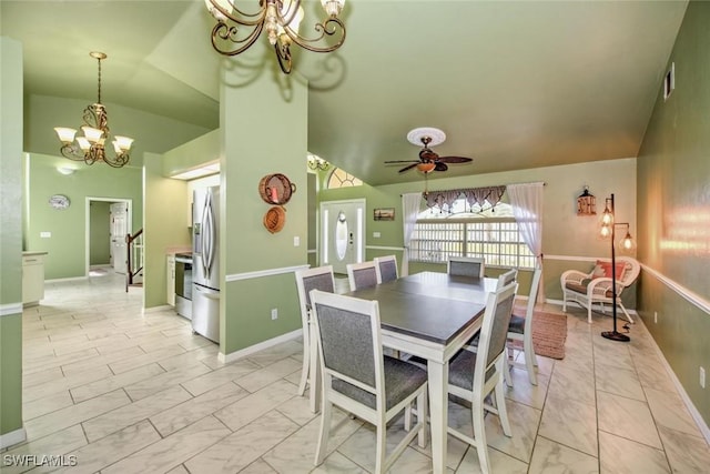 dining area featuring lofted ceiling and ceiling fan with notable chandelier