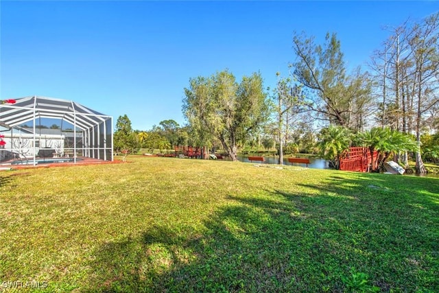 view of yard featuring a lanai and a water view