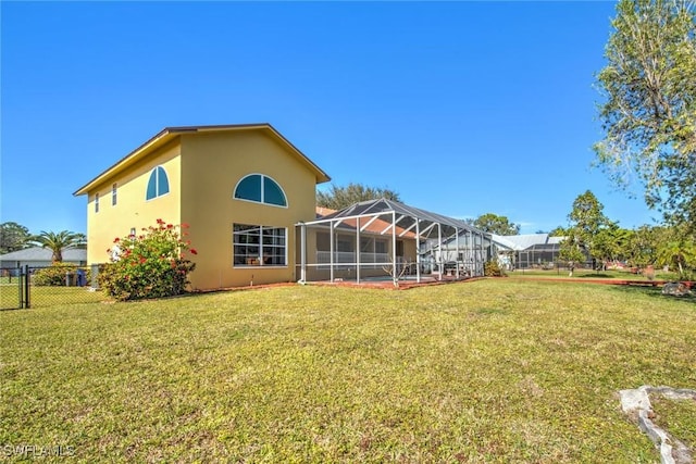 rear view of house featuring a yard and a lanai