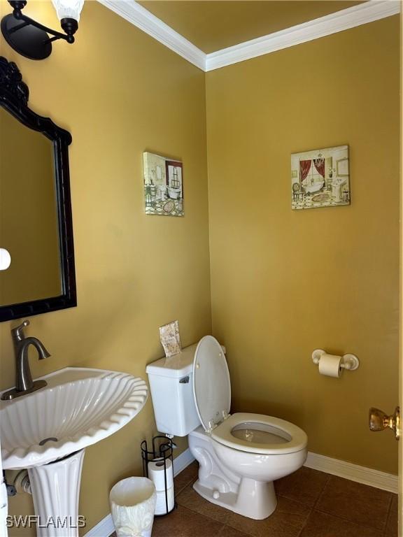 bathroom featuring crown molding, sink, tile patterned floors, and toilet