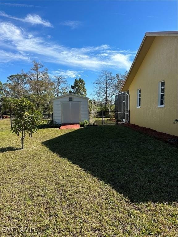 view of yard featuring glass enclosure and a storage unit