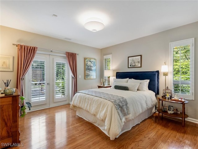 bedroom with access to outside, french doors, and light hardwood / wood-style flooring