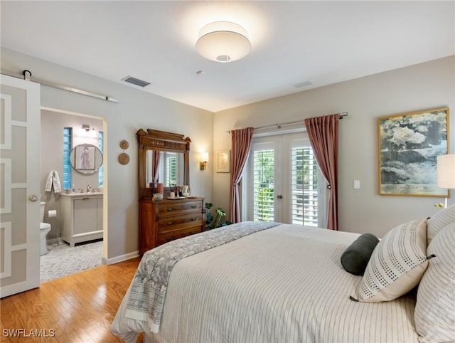 bedroom featuring access to outside, light hardwood / wood-style floors, and connected bathroom