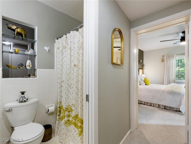 bathroom featuring toilet, tile walls, and ceiling fan