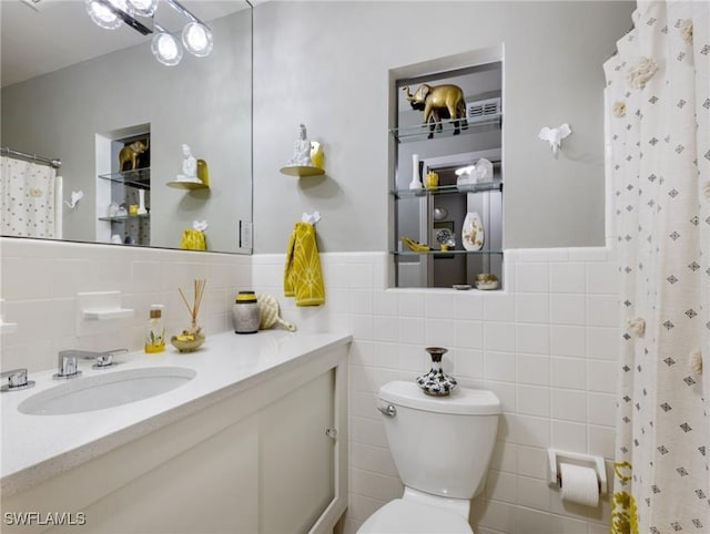 bathroom with toilet, vanity, tile walls, and curtained shower