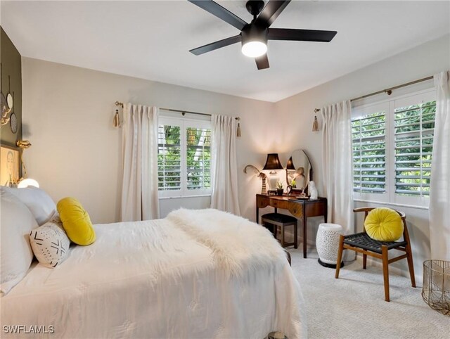 carpeted bedroom with ceiling fan and multiple windows