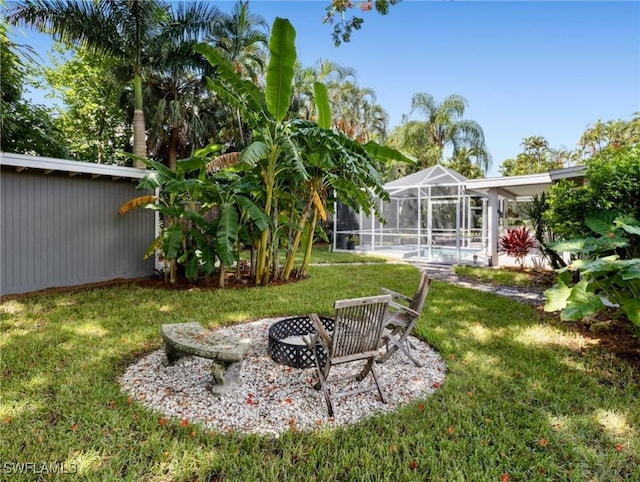 view of yard featuring a pool, a lanai, and a fire pit