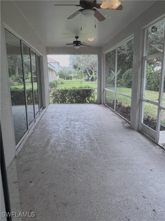 unfurnished sunroom featuring ceiling fan