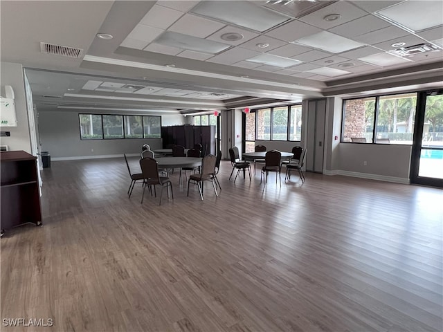 dining area featuring a drop ceiling and hardwood / wood-style floors