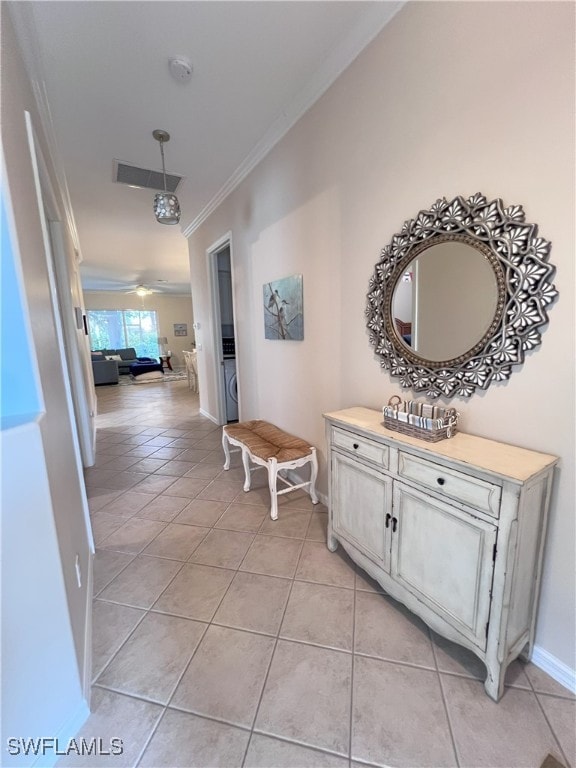 hallway featuring crown molding and light tile patterned floors