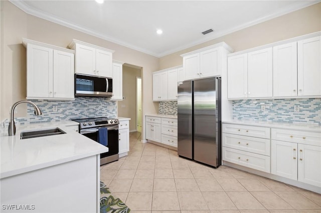 kitchen featuring light tile patterned flooring, sink, white cabinetry, crown molding, and appliances with stainless steel finishes